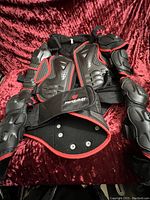 Full view of the junior large motocross protective armor showing chest and arm guards with black and red design and adjustable straps.