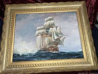 Full view of framed oil painting showing ship composition and decorative frame