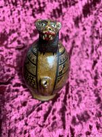 Front view of handcrafted Peruvian pottery vessel with animal face sculpture at vessel opening.
