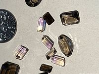 Close-up of faceted smokey quartz and ametrine gemstones highlighting color and cut details