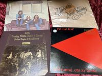 Photo of four vinyl album covers laid out on a surface. Albums include Crosby, Stills, Nash & Young, and Neil Young's Harvest and Re·ac·tor.