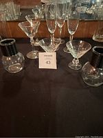 Photo showing entire glassware set including fluted stem glasses, cocktail glasses, small bowl, and vases with black ribbed accents on each side.