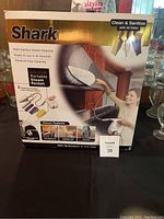 Front view of the Shark Deluxe Portable Steam Pocket cleaner box showing branding, product image, and key features including chemical-free cleaning and readiness in 25 seconds.