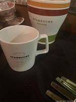 Starbucks ceramic cookie jar missing lid and Starbucks coffee mug displayed