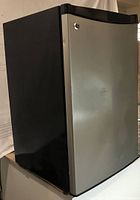 Overall view of General Electric bar fridge showing black casing with a brushed stainless steel door.