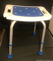 Photo of the blue and white adjustable shower stool with sturdy legs and rubber tips.