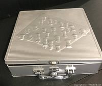 Silver metal box with embossed chessboard and chess pieces on lid