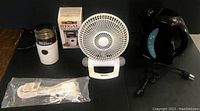 All items arranged side by side: coffee grinder, fan, electric kettle, and extension cord in plastic bag