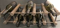 Wood grain wine rack stained dark brown holding 8 wine bottles horizontally, showing the rack construction and bottle holding capacity.