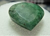 Faceted pear-shaped natural emerald gemstone showing color and inclusions