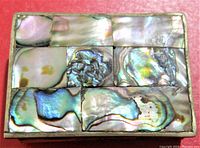 Top view showing rectangular abalone shell inlay on metal lid with iridescent colors and natural shell patterns.