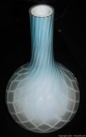 Side view of blue quilted art glass vase showing spiral neck and quilted base