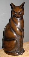 Front and side views of bronzed metal Siamese cat sculpture with smooth patina and detailed facial features highlighting Art Deco styling.