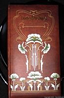 Front cover with reddish-brown embossed and raised floral design with gold accents and the words "Cartes Postales".