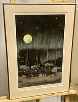Front view of framed limited edition print depicting northern lights over a small settlement with houses and full moon at night, signed by Jim Robb.