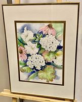 Framed watercolour painting showing a floral still life with white and pink flowers, signed by Pat Lavigne.