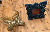 Photo of the hand blown glass swan dish and the carved wooden Mela artisan frame on wooden table.