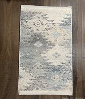 Front view of Jaipur Living indoor door mat rug showing geometric diamond pattern in muted gray and cream tones.