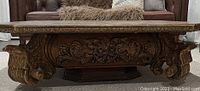 Front view showing carved floral Baroque details and gilt accents on solid wood coffee table base