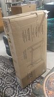 Sealed cardboard box of walnut finish breakfast table with assembly diagram and product details printed.