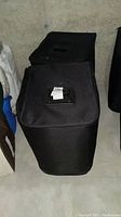 Two black zippered fabric storage cases side by side on concrete floor