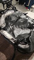 Black Thule rooftop cargo bag laid out showing size and material.
