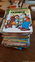 Stack of over 50 Walt Disney comics with visible titles including Walt Disney's Comics and Stories, Donald Duck comics