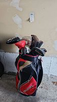 Front view of stand golf bag loaded with putters against garage wall