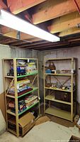 Two metal shelving units side by side in a basement with some items but contents not included.