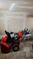 Full side view of red Toro snowblower showing engine, chute, wheels