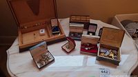 View of all jewelry items on display including cuff links, tie clips, and lapel pins in cases and loose.