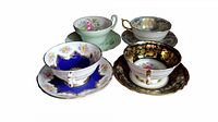 Overview of four teacup and saucer sets on white background