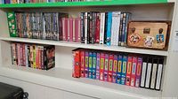 Two shelves of assorted DVDs and VHS tapes