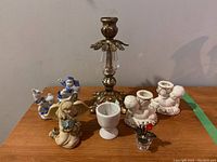 Overview of all items on a wooden surface including candle holders, figurines, and egg cup