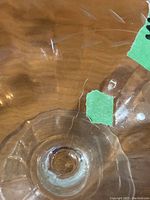Close-up of surface crack on one glass dessert dish showing damage and etched pattern
