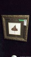 Front view of framed leaf print showing ornate wooden frame and single leaf print.