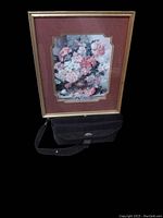 Full view of the floral print in gold-tone frame with reddish-brown mat on black stand showing overall condition and size.