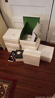 Multiple white boxes of unopened dinnerware and accessories on floor