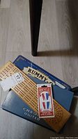 Wooden Cribbage board with Bicycle playing cards and Rummy-O box on floor
