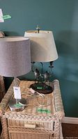 Both lamps pictured on wicker furniture against teal wall, showing size, colors, and condition.