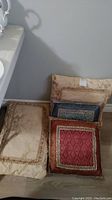 View of all four decorative pillows stacked and arranged showing variety of colors and patterns.