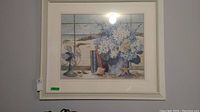 Frontal view of the framed print showing the coastal still life with flowers and vintage fan by window.