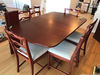 Table fully extended with one leaf installed and six chairs arranged around