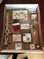 Full assortment of jewelry including necklaces, ring, brooches, pins, earrings in a box, showing general condition and layout