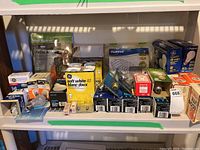 Various packages and loose lightbulbs arranged on a shelf with visible brand boxes and bulb types.