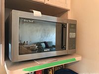 Front view of stainless steel Sanyo Euro Touch microwave model EM-S8600S on a shelf showing reflective door with branding and control panel on right side.