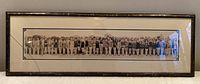 Full frontal view of framed panoramic print leaning against wall