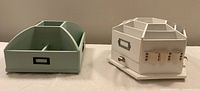 Two storage caddies side by side, green multi-compartment caddy and white rotating carousel caddy with elastic bands on the side.