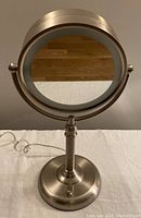 Front view of illuminated makeup mirror showing regular magnification side with light ring.