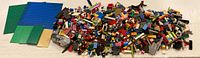 Full spread of mixed LEGO bricks and baseplates showing variety of pieces and colors.